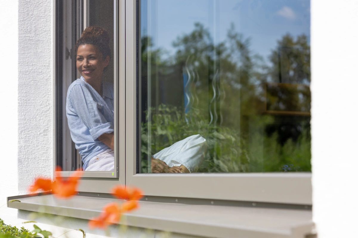 Insektenschutz Spannrahmen Grau mit Frau am Fenster